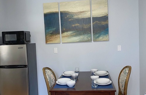 Coram Apartment | Cozy king suite with kitchen and dining area.