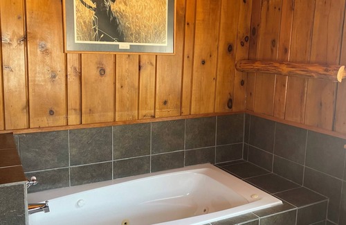 Itasca County Resort | Cozy queen bed in main Resort Lodge