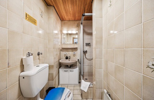 Wilhelmshaven Hotel | Cozy single room, flat-screen TV, and modern bathroom with shower. Ideal for singles and short stays – enjoy a relaxed atmosphere with warm wood accents and coastal charm.