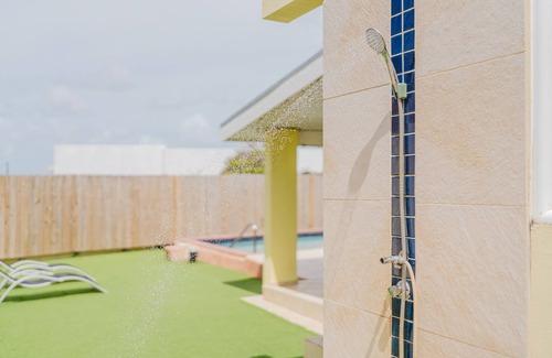 Shiribana Villa | Escape to Happy Daze Villa, a sunny 3-bedroom, 2-bathroom vacation home in a charming yellow setting