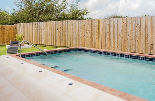Shiribana Villa | Escape to Happy Daze Villa, a sunny 3-bedroom, 2-bathroom vacation home in a charming yellow setting