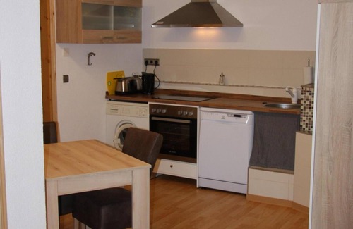 Friedrichroda House | Modernly furnished bungalow with fireplace, surrounded by greenery.
