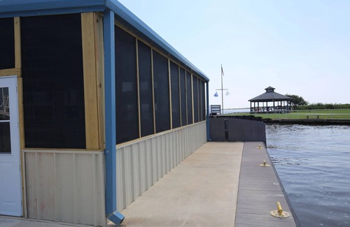 Sabine Pass Cottage | Park your boat in front of the Fishermen's Cottage! Screened in patio.