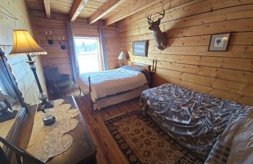 Buckinghorse River Cabin | Room 2 at the Main Lodge with a queen bed and single bed.
