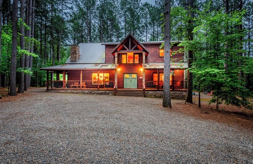 Broken Bow Cabin | Stepping into the Humble and Kind great room, you will be blown away by the wide open living - dining - kitchen floor plan, featuring 20' tall soaring cathedral ceilings, which showcase a gorgeous rock wood-burning fireplace and a huge Smart TV.