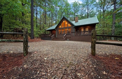 Broken Bow Cabin | Stepping into the Humble and Kind great room, you will be blown away by the wide open living - dining - kitchen floor plan, featuring 20' tall soaring cathedral ceilings, which showcase a gorgeous rock wood-burning fireplace and a huge Smart TV.
