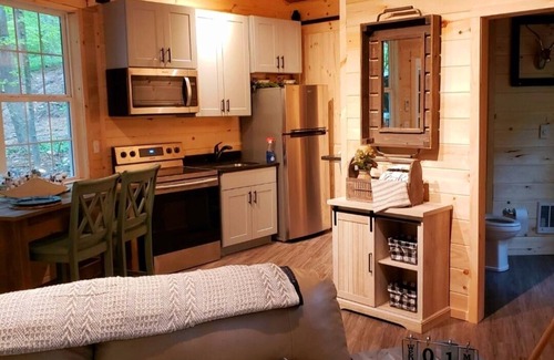 Darlington House | The Chalet is located in the woods of a gated property with a covered porch.