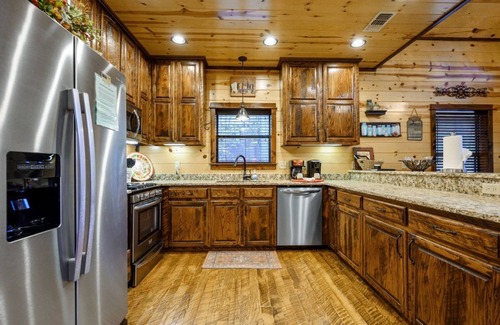 Broken Bow Cabin | This luxury two-bedroom luxury log cabin is designed and furnished in true rustic elegance. You will love the beautiful hand-scraped hardwood floors, giant hand-hewn dark oak beam accents to the knotty pine walls, granite counters, ceiling fans, stai