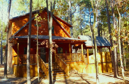 Broken Bow Cabin | This luxury two-bedroom luxury log cabin is designed and furnished in true rustic elegance. You will love the beautiful hand-scraped hardwood floors, giant hand-hewn dark oak beam accents to the knotty pine walls, granite counters, ceiling fans, stai