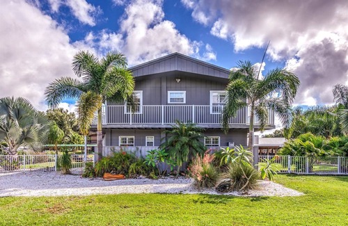 Fedhaven House | Tropical Lake House with waterfront tiki bar and wrap around porch