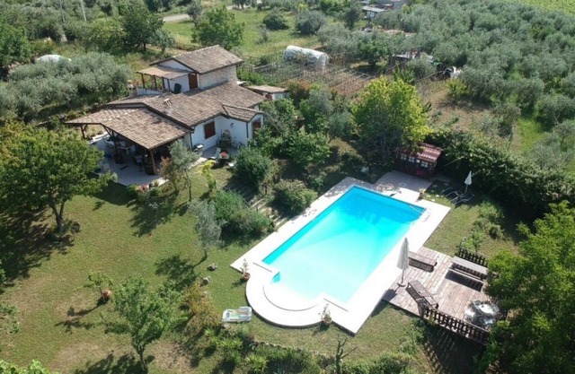 Country house with swimming pool surrounded by an orchard