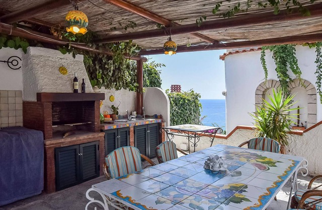 Inviting cottage with charming outdoor area and limited sea view.