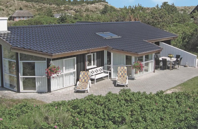 On a planted dune plot not far from the beach lies this well-kept and cozy luxury house with a glass