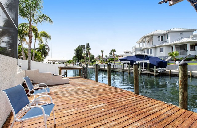 Riverfront home with screened private pool, outdoor kitchen, & water access