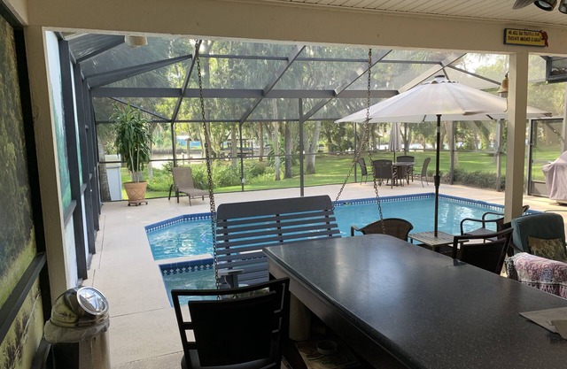 Tampa area home with solar-heated pool, hot tub, river and large dock.