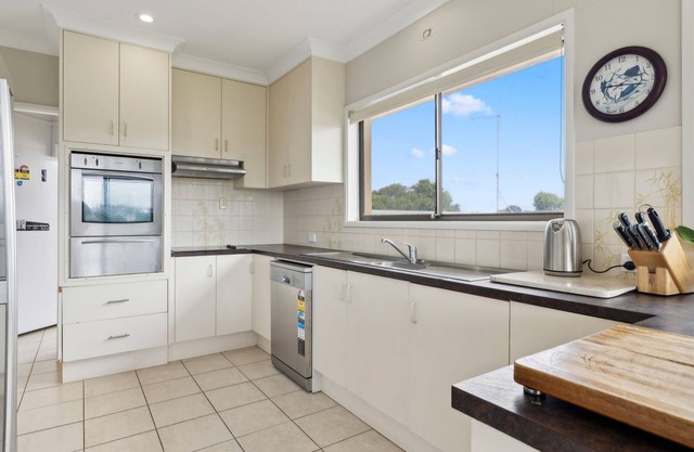You’ll love being front row on Sandy Beach in this airy elevated holiday home.