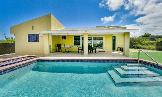 Shiribana Villa | Escape to Happy Daze Villa, a sunny 3-bedroom, 2-bathroom vacation home in a charming yellow setting
