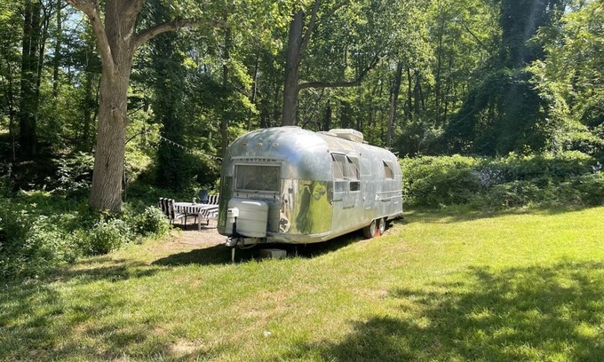 Changewater RV Rental | Modern Styled Vintage Airstream Nestled by a Stream on a Picturesque Tree Farm