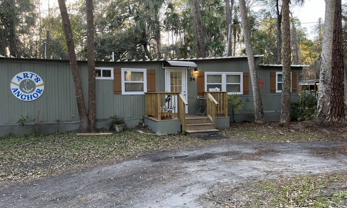 Inglis Apartment | Step into this cozy 2-bedroom cabin nestled in the tranquil woods. The main living area offers comfy seating, including a pull-out futon for additional sleeping space. An efficiency kitchen awaits your culinary adventures, equipped with essentials fo