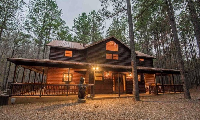 Broken Bow Cabin | Stepping into the Humble and Kind great room, you will be blown away by the wide open living - dining - kitchen floor plan, featuring 20' tall soaring cathedral ceilings, which showcase a gorgeous rock wood-burning fireplace and a huge Smart TV.
