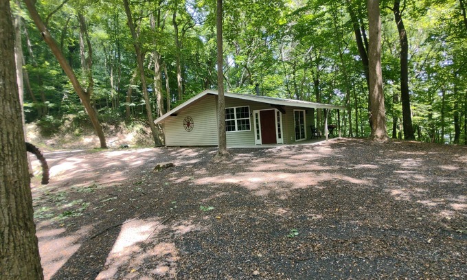 Darlington House | The Chalet is located in the woods of a gated property with a covered porch.