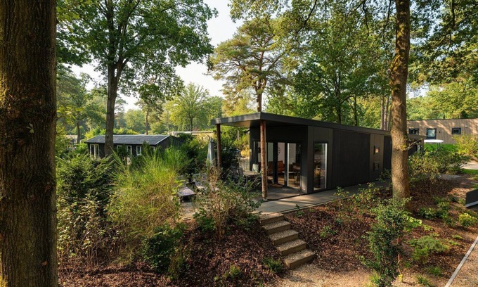 Lieren House | Zand Lodge is a charming chalet for 6 people in the Veluwe, featuring a warm wooden interior, a fully equipped kitchen, and a covered terrace.